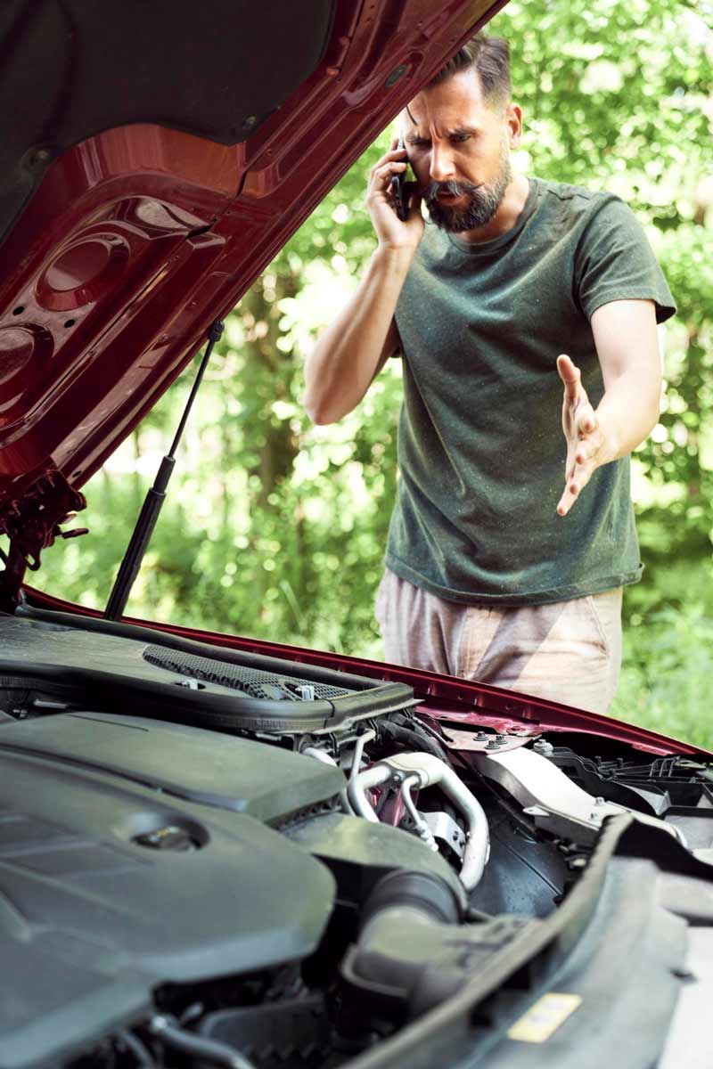 Junger Mann prüft Getriebeschaden bei Schrottauto Ankauf Siegburg